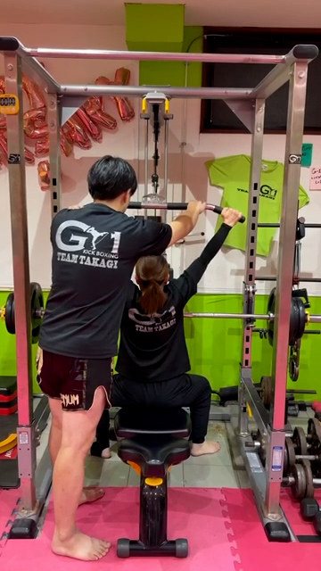 トレーナーがフォームを指導するパーソナルトレーニング風景